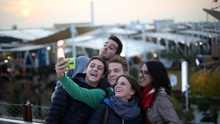 cinque giovani si scattano un selfie